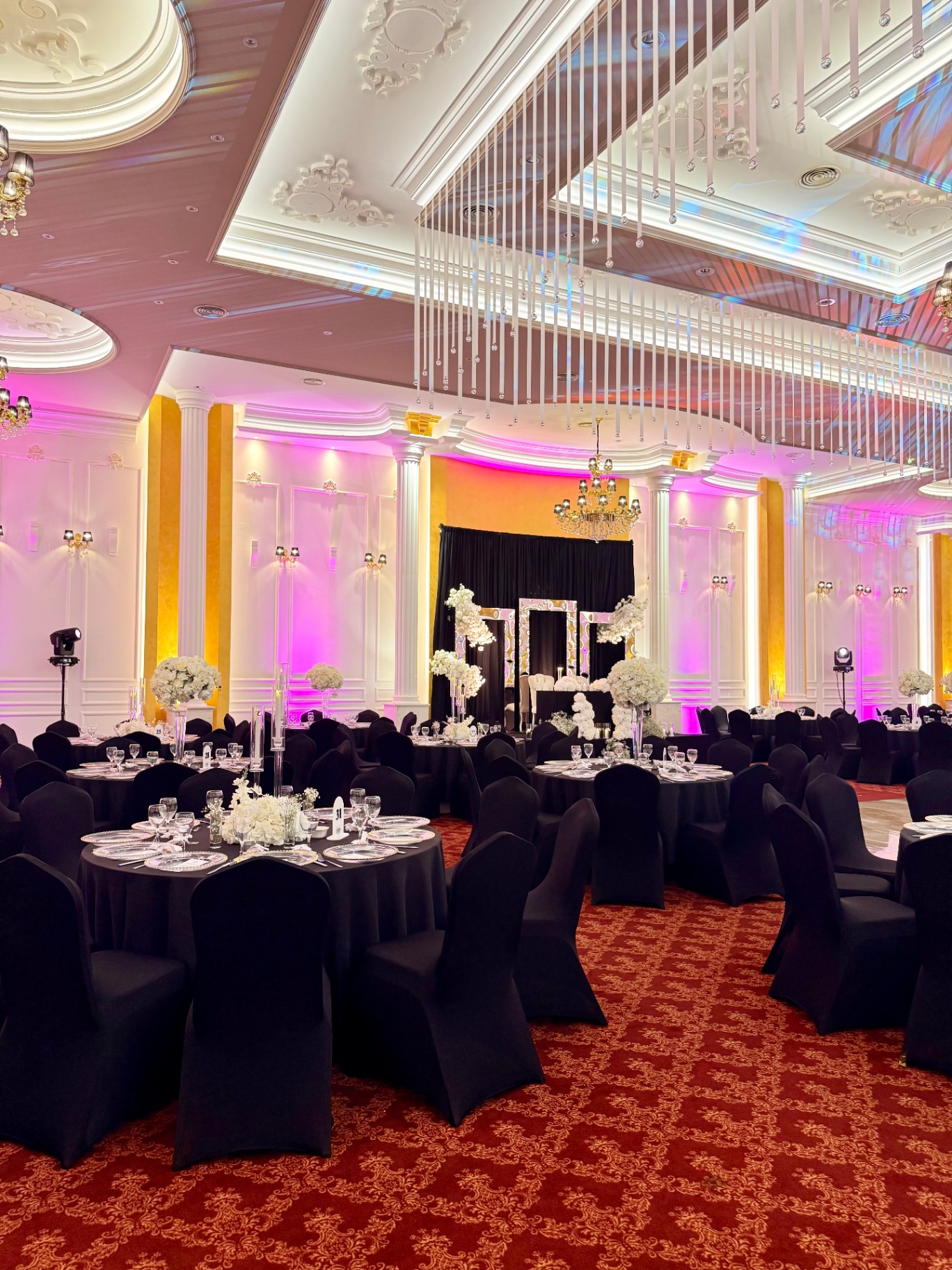 Sallë dasme me dritë rozë dhe dekor floral i bardhë